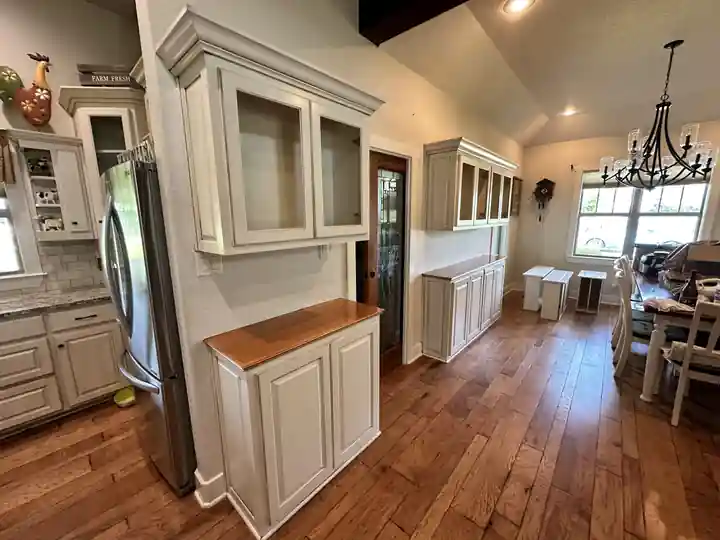 Painted kitchen cabinets with glass-front uppers and wood counters