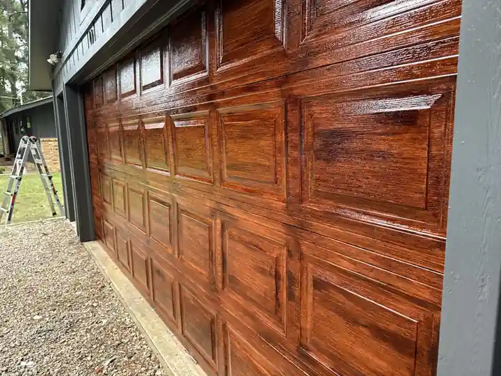 A steel garage door hand-finished in faux wood grain