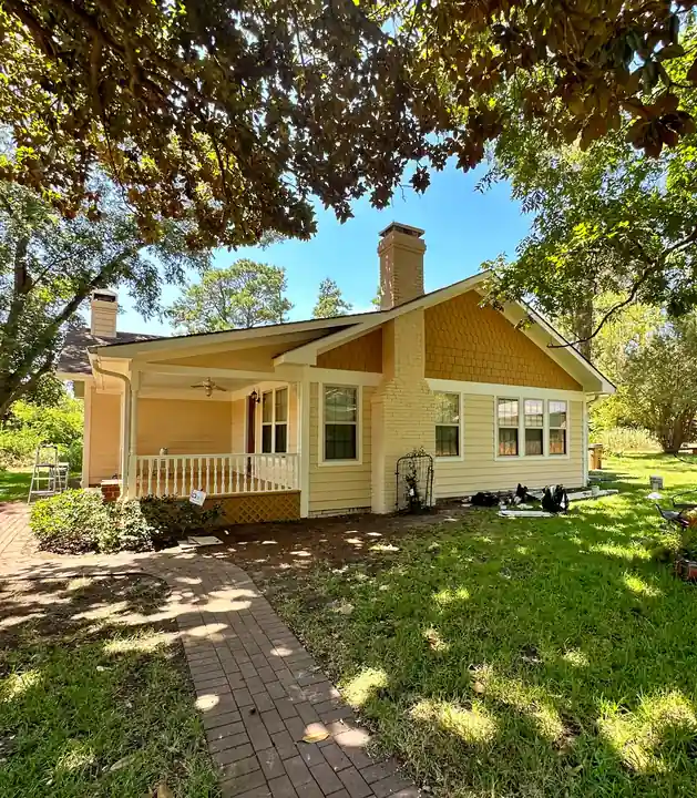 A yellow craftsman bungalow with a porch