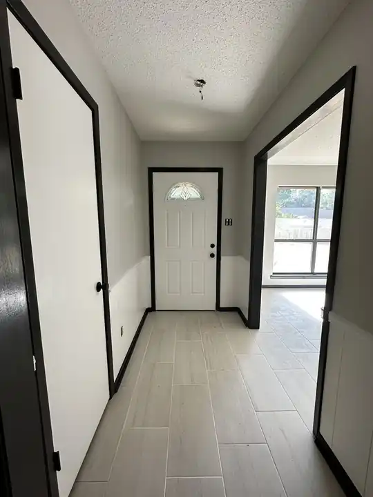An entry with white walls and black door casings
