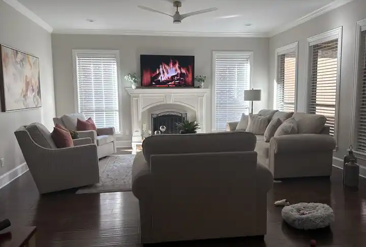 Living room with soft neutral walls, crisp white trim and a fireplace