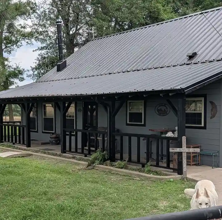 Modern farmhouse exterior with gray siding, black trim and a metal roof